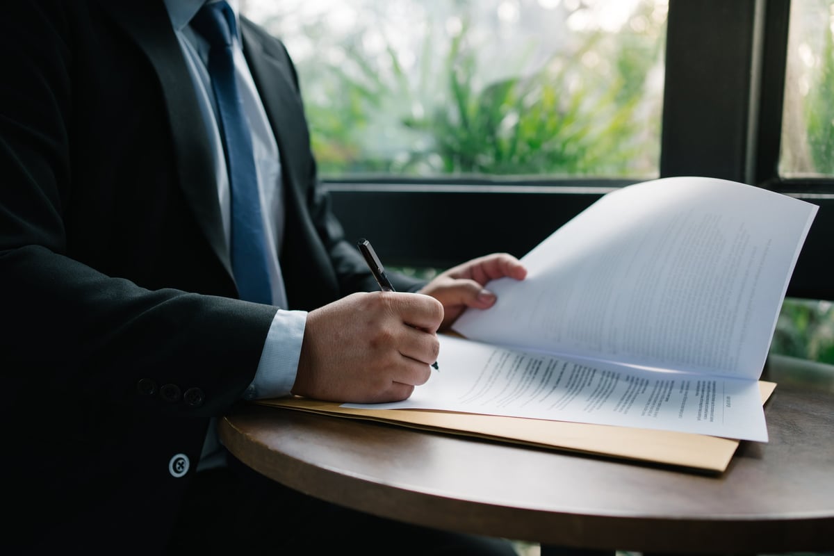 Business professional signing a document, closing a legal agreement and contract