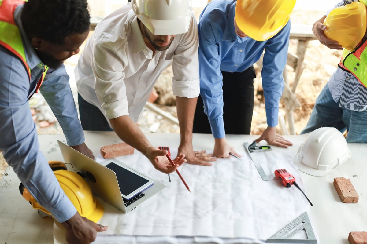 Engineers and staff meeting to assess the progress of a residential construction site